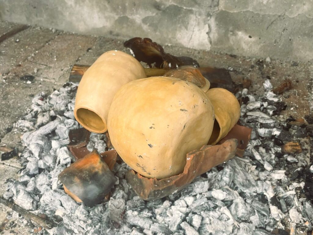unfired earthenware placed onto coals for diy ollas
